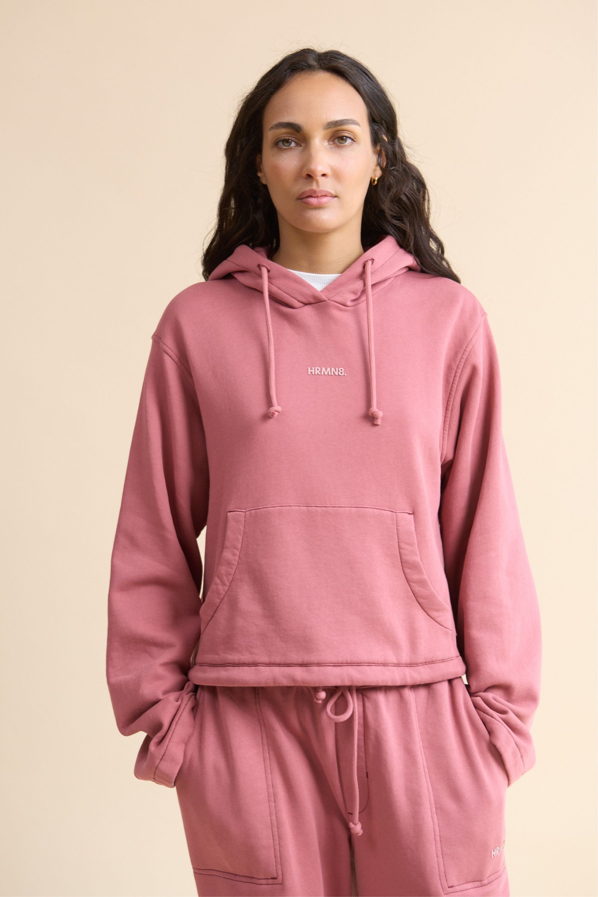 Women's HRMN8 activewear dusty pink cropped hoodie with wide sleeves, central pocket, and adjustable drawstring hood 