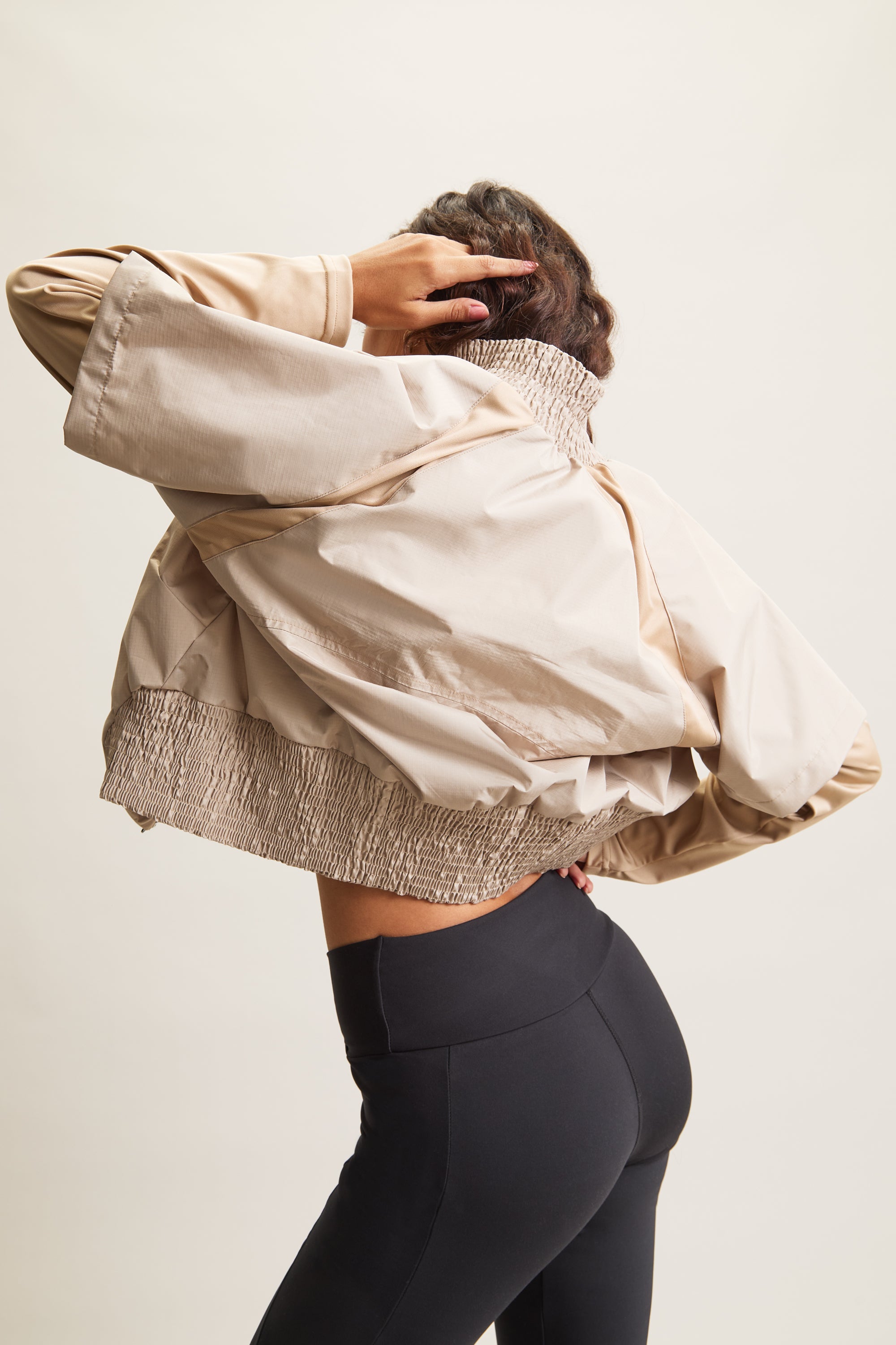 Women's HRMN8 beige, cream, brown Pace Jacket with buttery-soft sleeves, lightweight nylon shell, and elasticated waist for a flattering fit. Designed for movement, this versatile zip-up jacket is ideal for activewear, athleisure, and post-workout layering. Pairs effortlessly with Stride Flare Pants for a sporty, gym-ready look or with Persuasion Linen Pants for a contemporary, everyday outfit. A must-have for modern street style, travel, and transitional seasonal wear.
