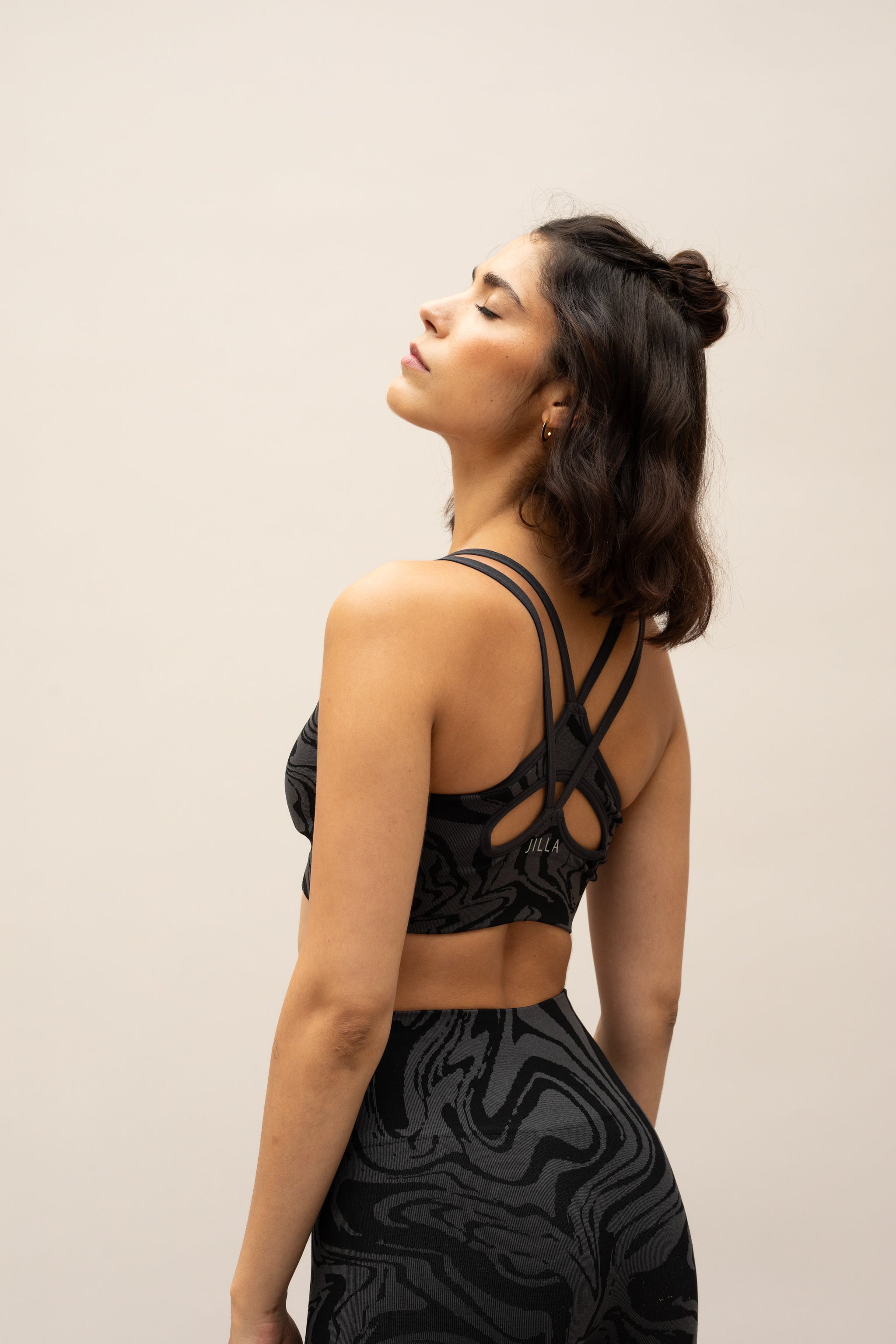 Black grey charcoal recycled seamless marble print low to medium impact supportive sports bra for yoga, pilates, spinning, weights, running and exercise by sustainable activewear brand Jilla Active 