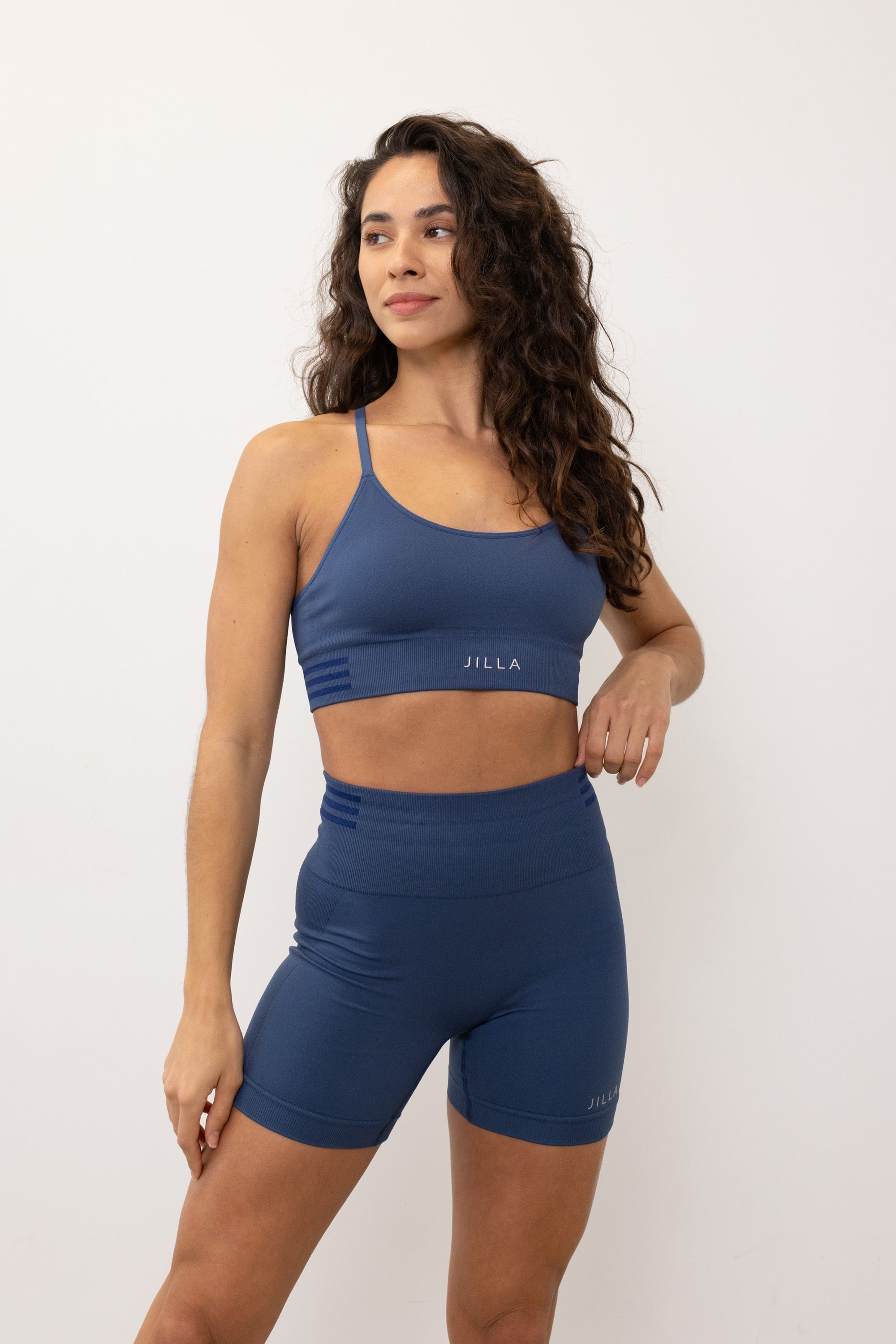 Introducing our denim blue Tone & Lift Recycled Shorts: Your go-to for summer workouts! Made with four-way stretch fabric and ribbing panels, they offer a flattering fit for any activity. Featuring a high-rise ribbed waistband and 5" inseam, they ensure comfort and style. With contrasting colors and internal elastic, they're both fashionable and functional. Pair with our matching bra and Sky's The Limit Oversized T-shirt for a complete look.