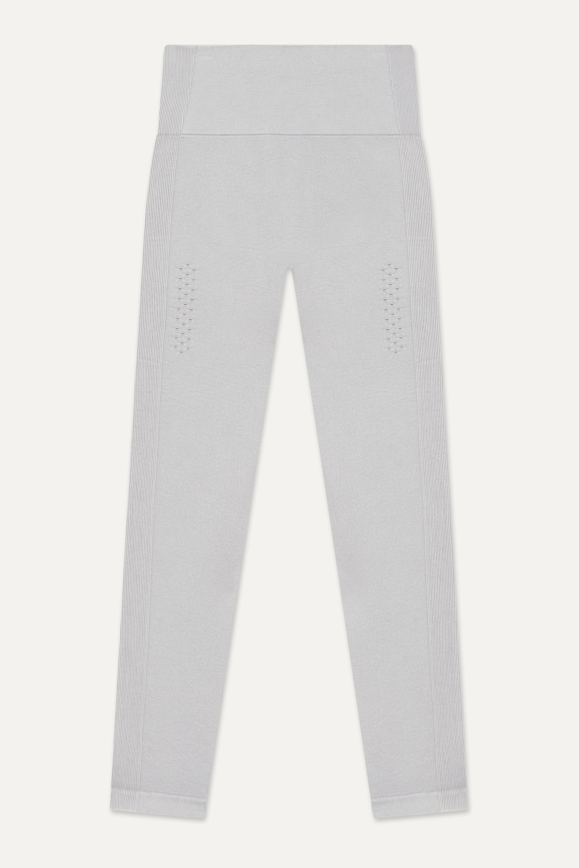 Our light grey Aquarius Recycled Leggings - crafted for seamless performance in your yoga flows, barre workouts, and reformer classes. Made from four-way stretch fabric, they move effortlessly with you. Designed with flattering ribbing and an acid wash effect, each pair is unique. The high-rise ribbed waistband with internal elastic ensures they stay in place during your entire class, while the double-layered gusset provides all-day comfort and flexibility. 