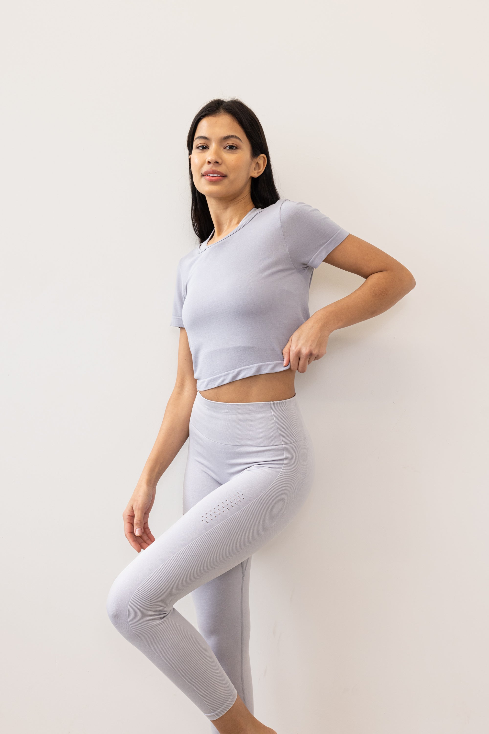 Meet our light grey Frances Modal Tee - your go-to for yoga or any workout! With a cropped length and low back, it's perfect for layering over leggings and a sports bra. Crafted from gentle Lenzing modal fabric blended with recycled polyamide, it offers unmatched softness and comfort. Cut to meet your leggings' waistband, it's a versatile must-have for your activewear collection. Experience comfort and style with Frances Modal Tee by Jilla Active