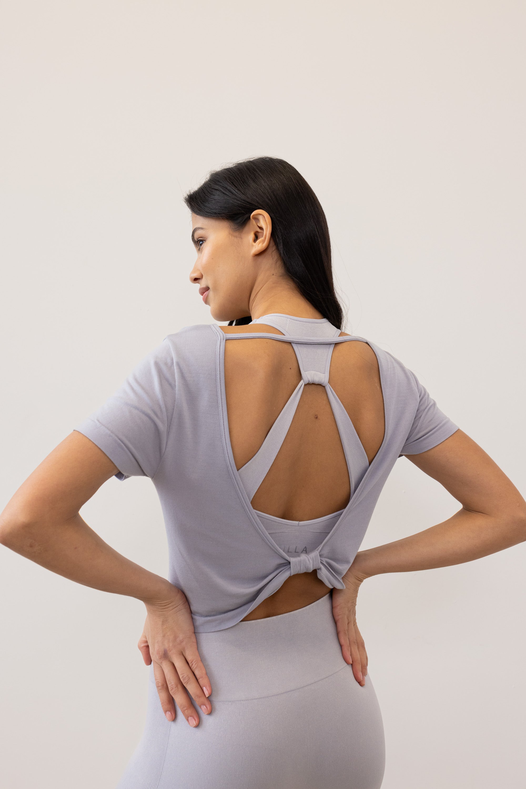 Meet our light grey Frances Modal Tee - your go-to for yoga or any workout! With a cropped length and low back, it's perfect for layering over leggings and a sports bra. Crafted from gentle Lenzing modal fabric blended with recycled polyamide, it offers unmatched softness and comfort. Cut to meet your leggings' waistband, it's a versatile must-have for your activewear collection. Experience comfort and style with Frances Modal Tee by Jilla Active