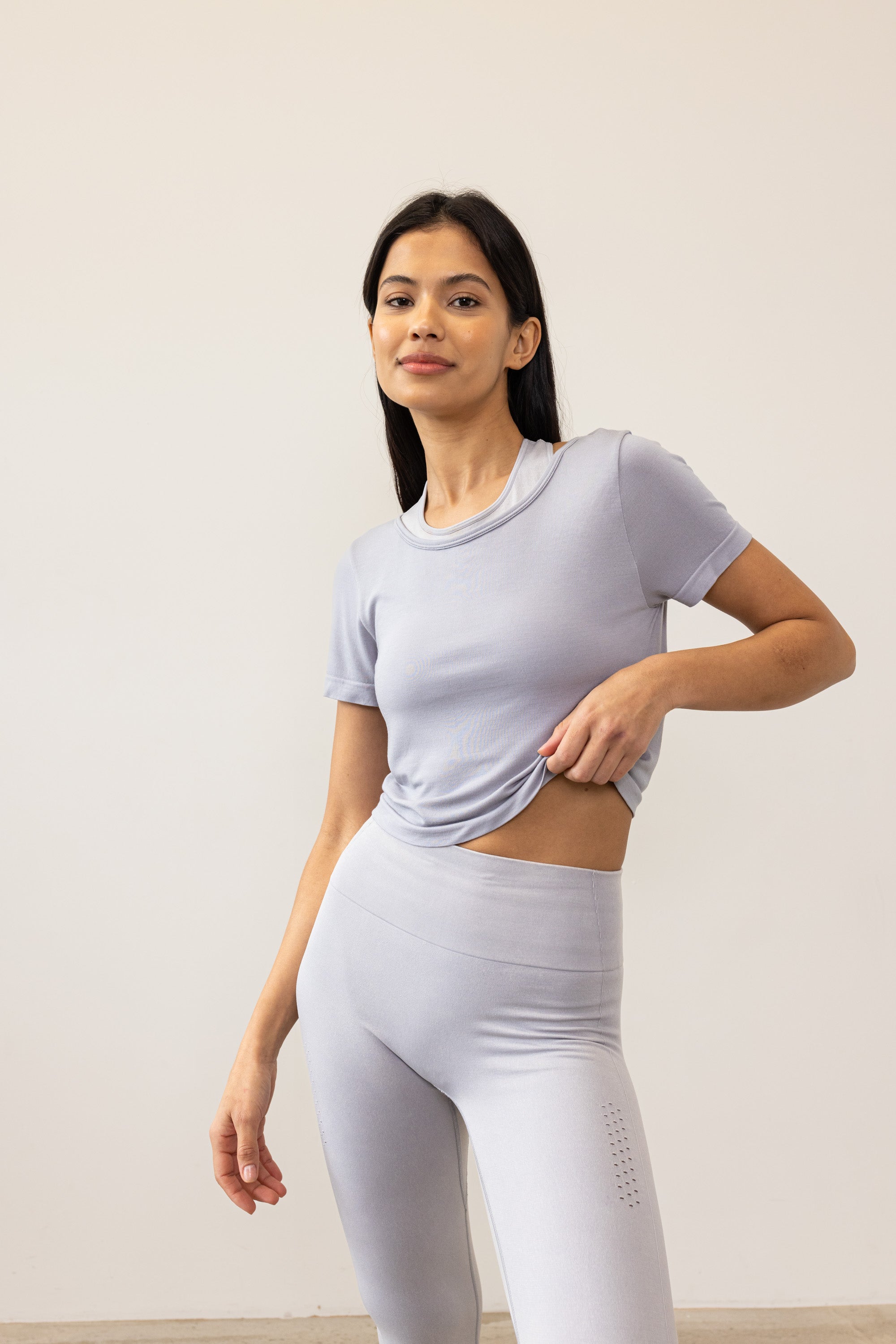 Meet our light grey Frances Modal Tee - your go-to for yoga or any workout! With a cropped length and low back, it's perfect for layering over leggings and a sports bra. Crafted from gentle Lenzing modal fabric blended with recycled polyamide, it offers unmatched softness and comfort. Cut to meet your leggings' waistband, it's a versatile must-have for your activewear collection. Experience comfort and style with Frances Modal Tee by Jilla Active