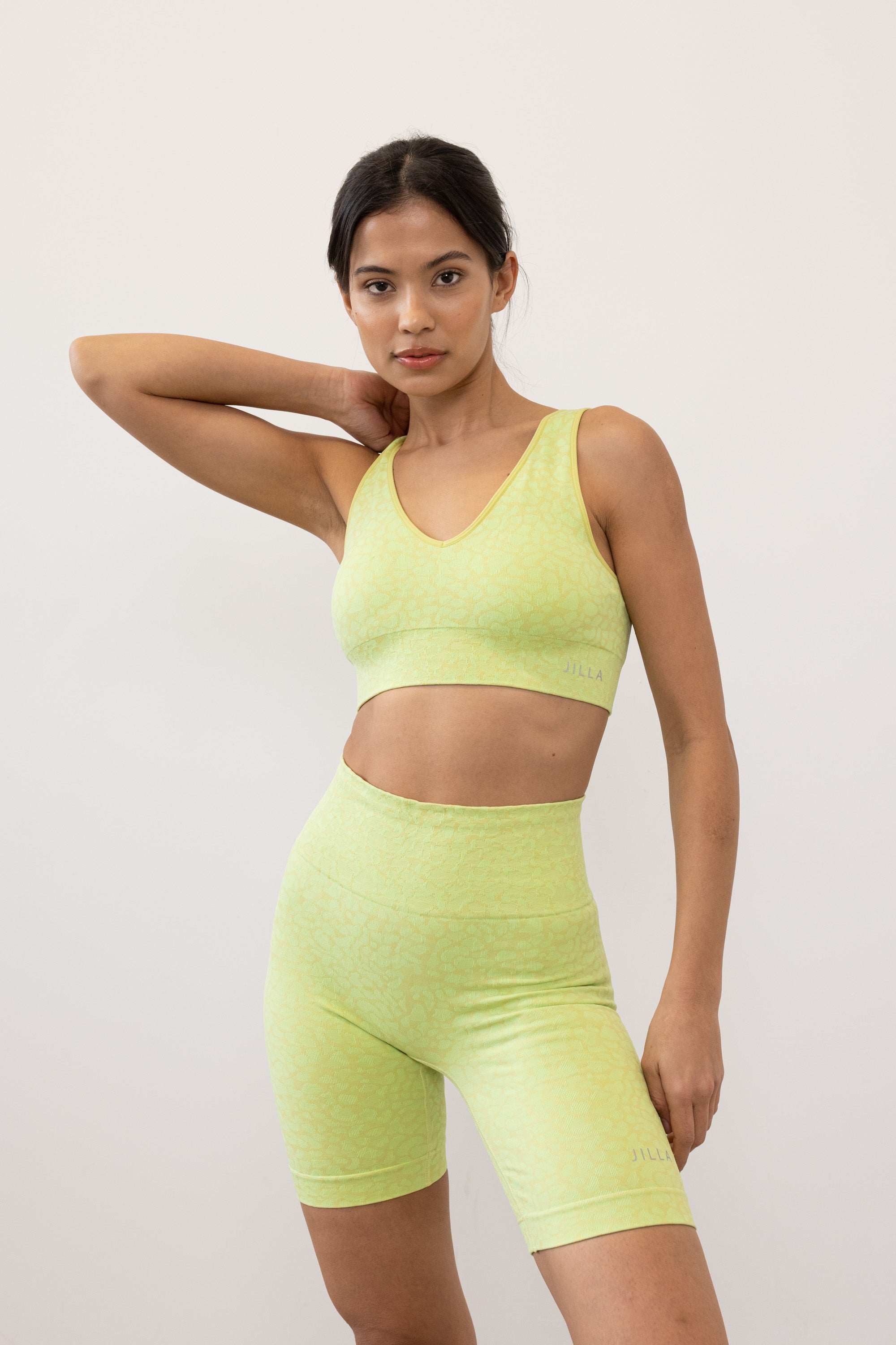 Prepare for summer with our Sahara Recycled Shorts in lime acid green, seamlessly knitted in our new animal jacquard. With a wide ribbed waistband and a mid-thigh finish, they're perfect for studio classes, gym workouts, and everyday style. The internal waistband elastic and four-way stretch fabric ensure they stay in place all day. Complete your look by pairing them with the matching bra and oversized tee.