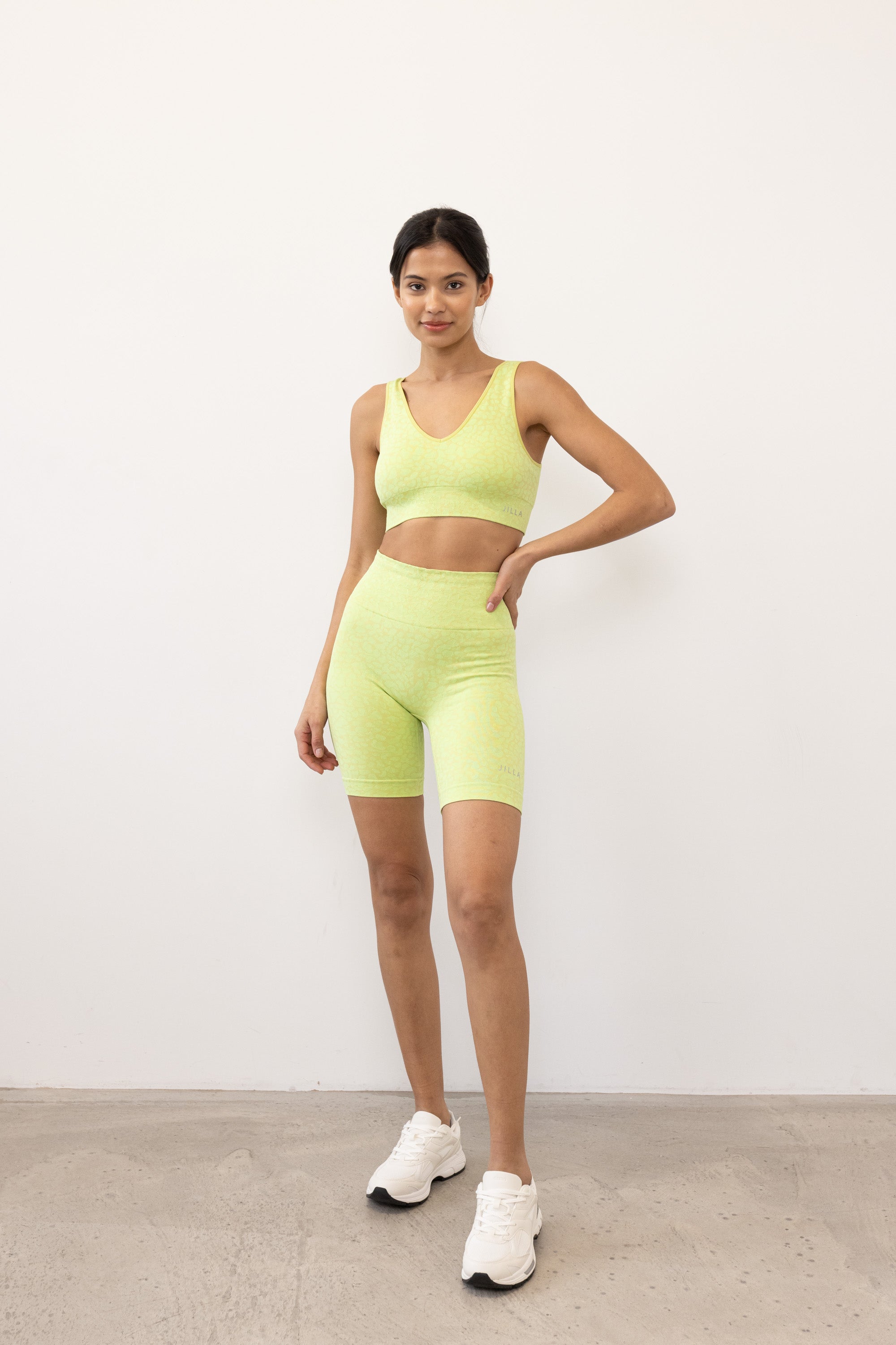 Prepare for summer with our Sahara Recycled Shorts in lime acid green, seamlessly knitted in our new animal jacquard. With a wide ribbed waistband and a mid-thigh finish, they're perfect for studio classes, gym workouts, and everyday style. The internal waistband elastic and four-way stretch fabric ensure they stay in place all day. Complete your look by pairing them with the matching bra and oversized tee.