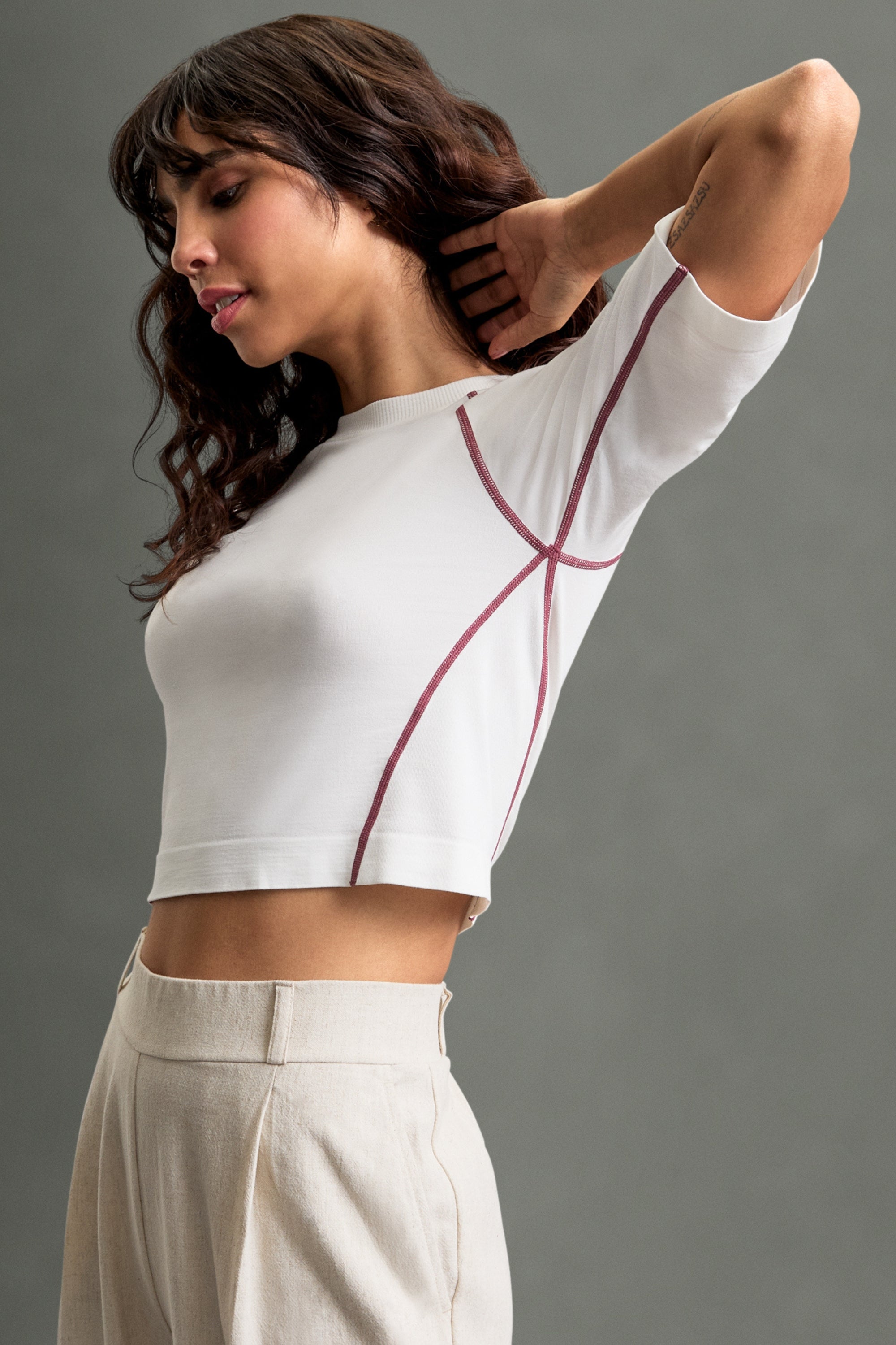 Women's HRMN8 white pink Reform Tee in ultra-soft nylon with a seamless design, subtle side texture, and contrast stitch detailing. Features a lightweight feel and longer sit sleeves for a flattering, sculpted fit. Designed for athleisure, activewear, and everyday layering. Pairs effortlessly with the Persuasion Pants and Staple Jacket for a refined look or the Allure Set for a relaxed, leisure-inspired style. Ideal for gym workouts, casual wear, or elevated layering.