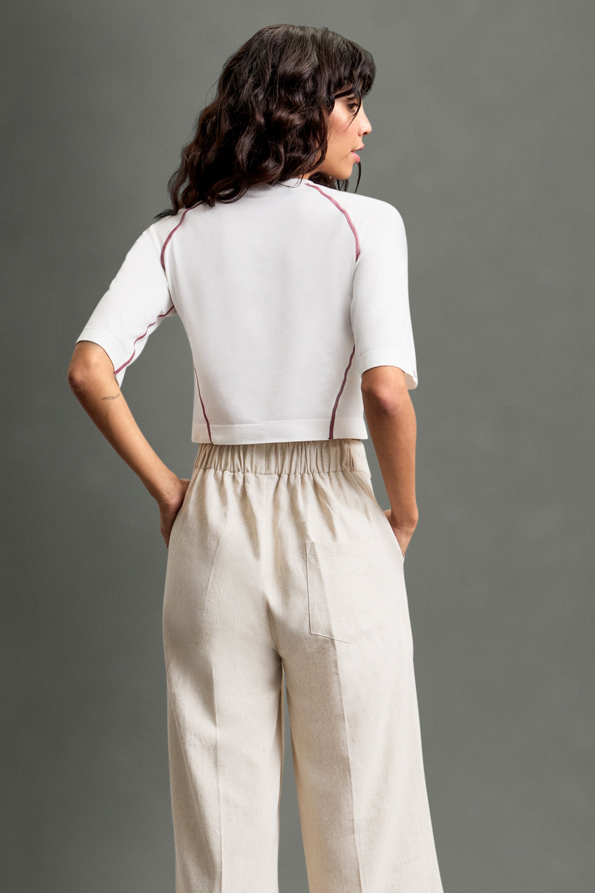 Women's HRMN8 white pink Reform Tee in ultra-soft nylon with a seamless design, subtle side texture, and contrast stitch detailing. Features a lightweight feel and longer sit sleeves for a flattering, sculpted fit. Designed for athleisure, activewear, and everyday layering. Pairs effortlessly with the Persuasion Pants and Staple Jacket for a refined look or the Allure Set for a relaxed, leisure-inspired style. Ideal for gym workouts, casual wear, or elevated layering.