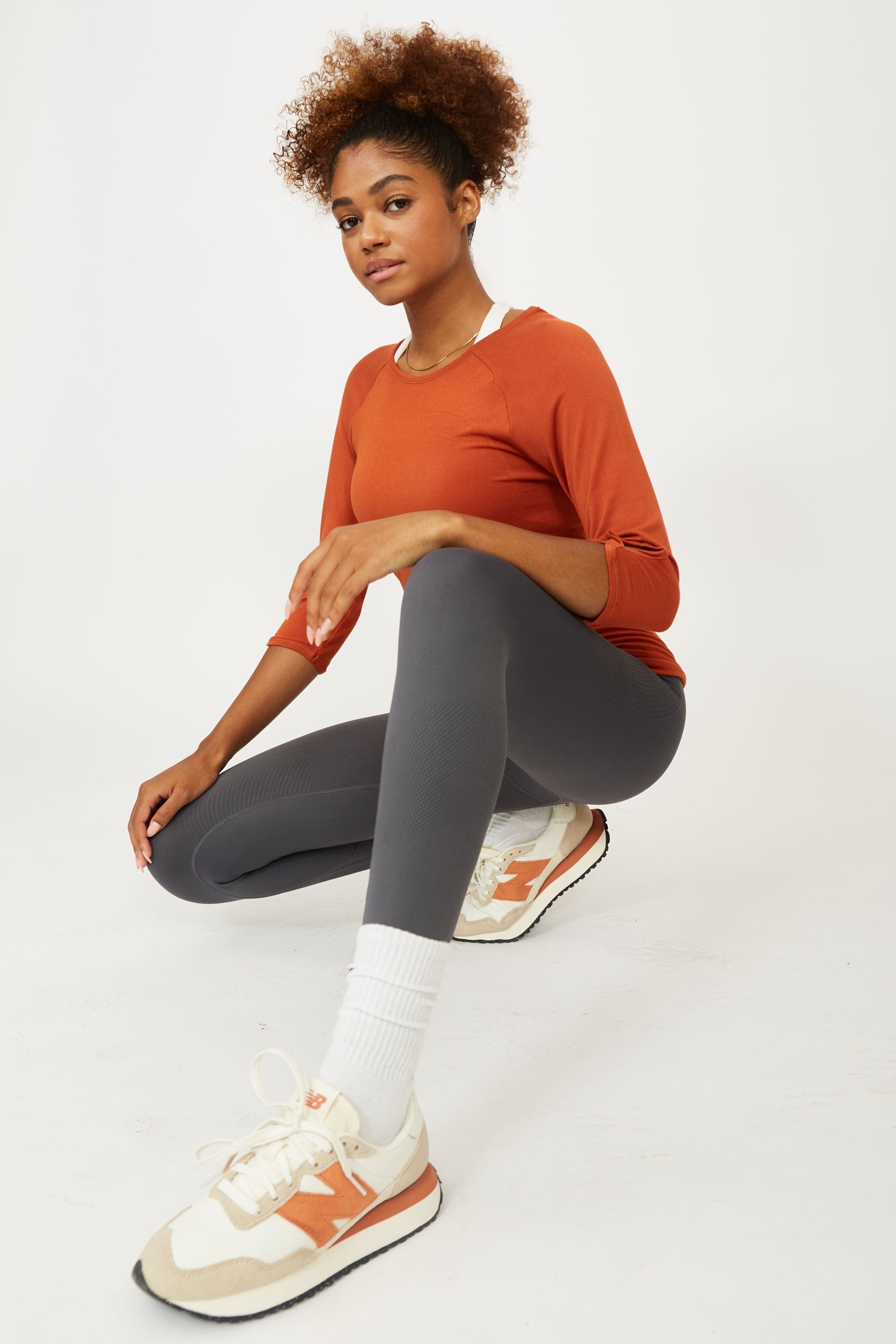 Model wearing grey leggings and white supportive sports bra for sustainable activewear brand, Jilla.